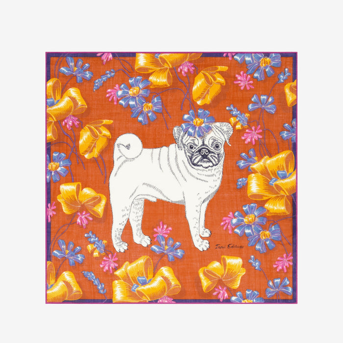 A woman with blonde hair, wearing a tan sweater and the INOUI TOUTOU DOG SCARF IN ORANGE, stands facing the camera against a plain white background.