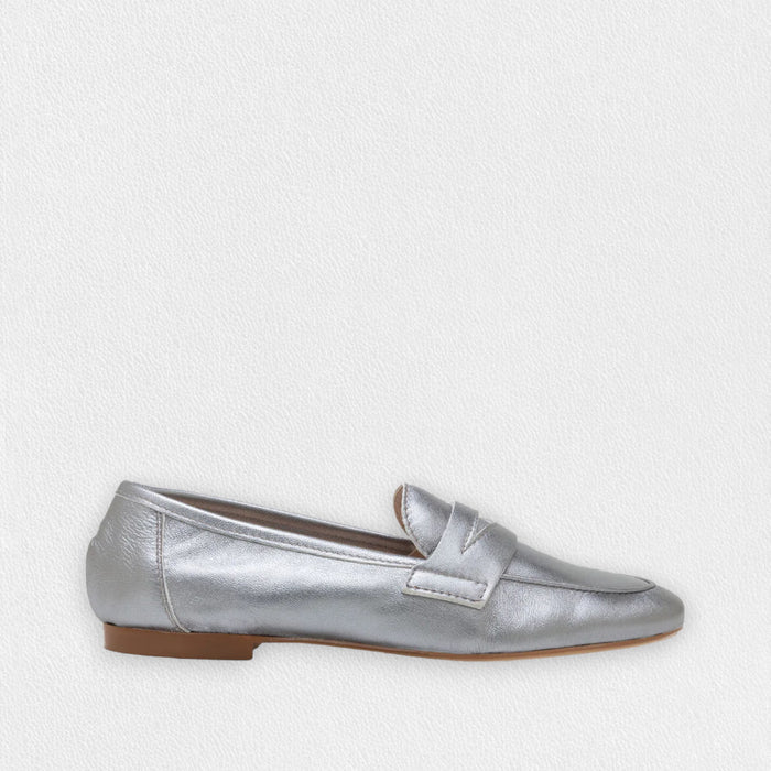 The MICHELE LOPRIORE - PAOLA LOAFER is a black genuine leather loafer with a low heel, almond toe, and simple stitched design, shown in profile against a light textured background.