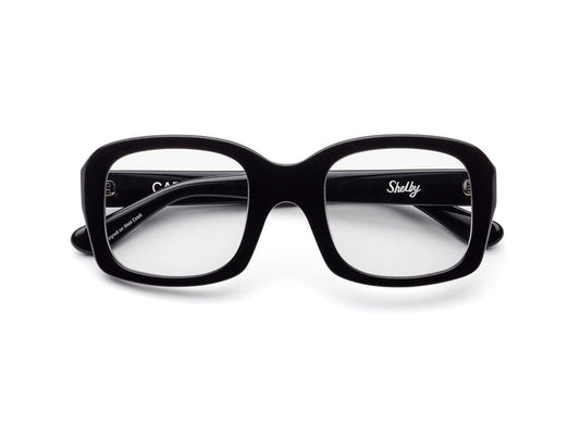 CADDIS - SHELBY PROGRESSIVE READERS by CADDIS are black, square, thick-rimmed eyeglasses with oversized frames and clear, scratch-resistant lenses. Shown front-facing on white; "Shelby" printed in white inside the left arm.