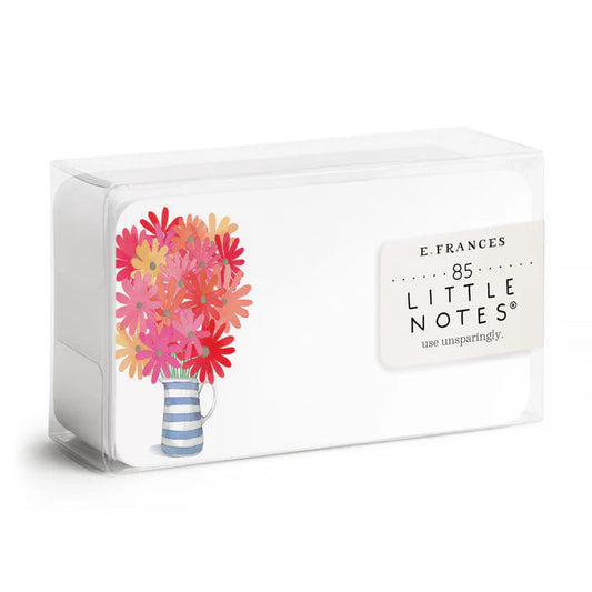 A clear plastic box of E. FRANCES PAPER's "Freshly Picked Little Notes" contains 85 notecards, each featuring a watercolor bouquet of pink and red flowers in a blue and white striped mug, labeled "E. Frances 85 Little Notes - use unsparingly.