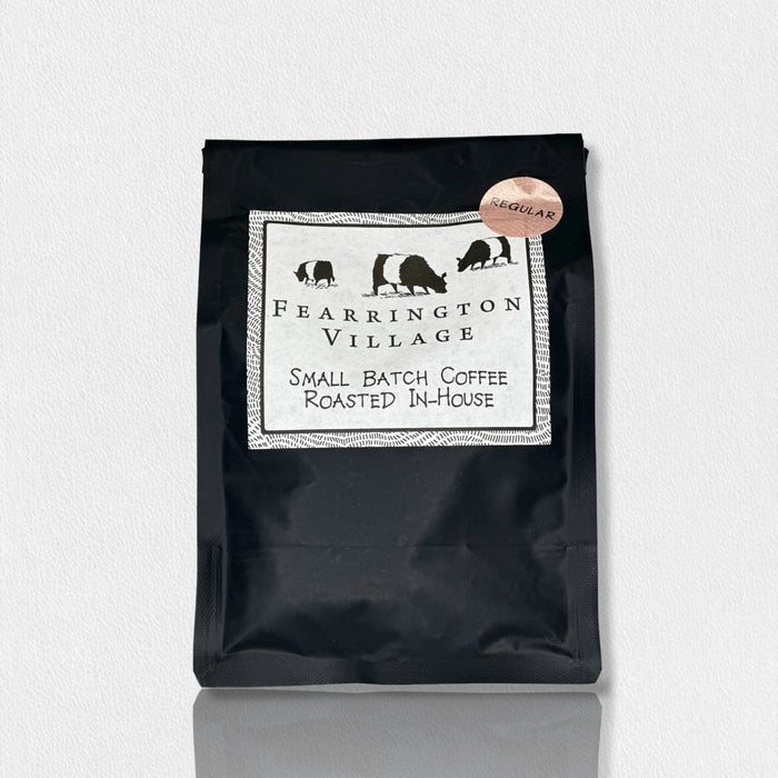 A black bag of BELTED GOAT’s FEARRINGTON SIGNATURE COLLECTION - SMALL BATCH HOUSE BLENDED REGULAR COFFEE BEANS, labeled “Small Batch Coffee Roasted In-House,” features animal silhouettes and a “Regular” sticker, inspired by Papua New Guinea beans.