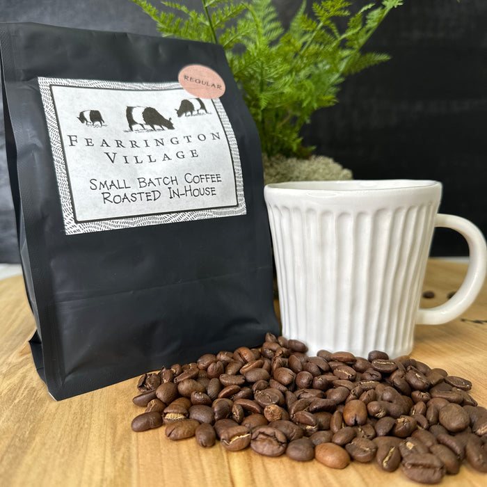 A black bag of BELTED GOAT’s FEARRINGTON SIGNATURE COLLECTION - SMALL BATCH HOUSE BLENDED REGULAR COFFEE BEANS, labeled “Small Batch Coffee Roasted In-House,” features animal silhouettes and a “Regular” sticker, inspired by Papua New Guinea beans.