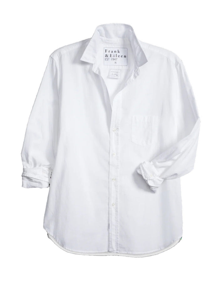 The EILEEN Relaxed Button-Up by Frank & Eileen features a white chambray fabric with long sleeves, a chest pocket, and bust-flattering buttons. The collar displays "Frank & Eileen EST. 1947," while the sleeves are slightly rolled for a casual look.