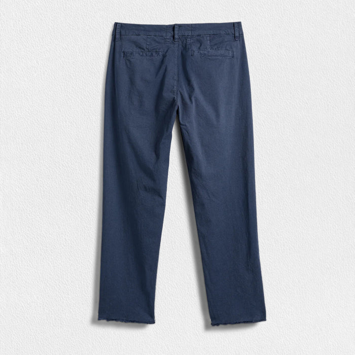 A pair of FRANK & EILEEN’s THE WICKLOW Italian Chinos in Performance Twill, featuring a navy blue color, straight legs, and raw unfinished hems, is laid flat on a light textured background for an Italy-meets-California vibe.