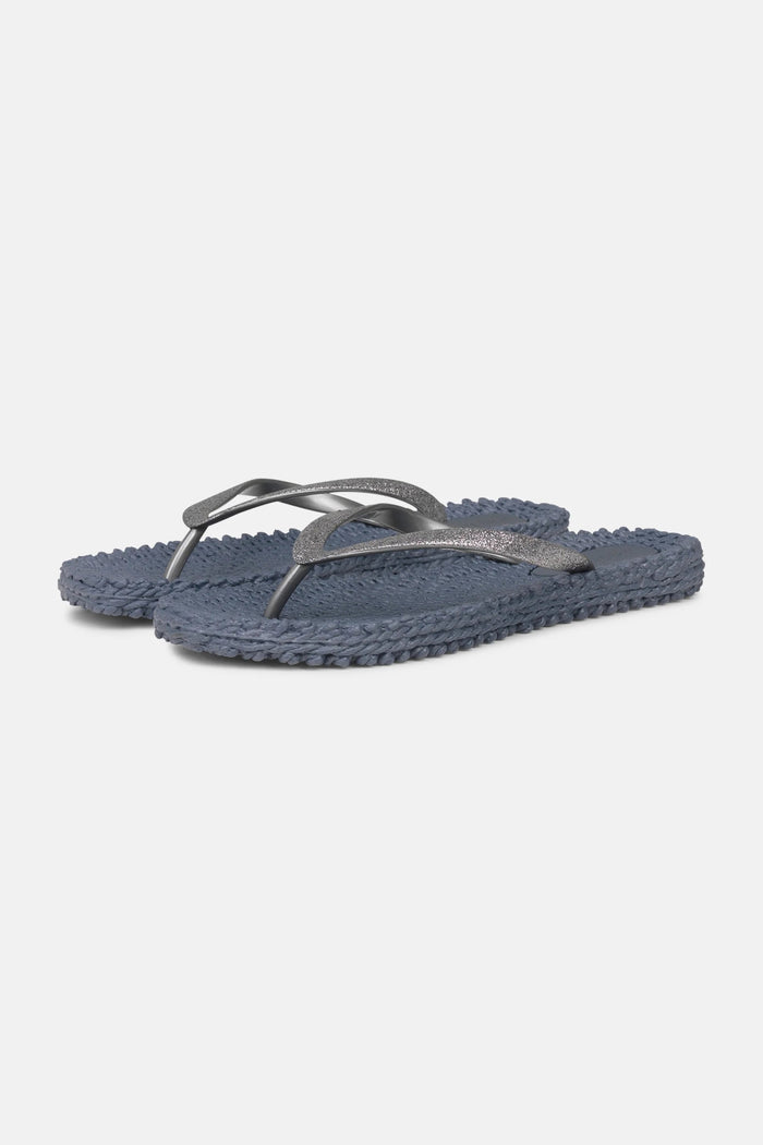 The ILSE JACOBSEN CHEERFULL flip flops in grey by LINES OF DENMARK feature textured soles and glitter thong straps, shown side by side on a plain white background.