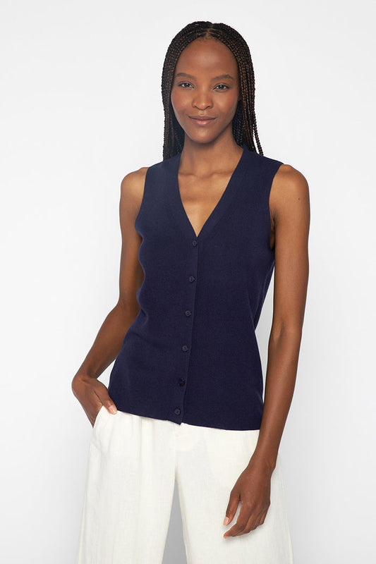 Close-up of the KINROSS CASHMERE - BUTTON VEST by KINROSS reveals a textured, off-white surface with a subtle woven pattern, evoking the refined feel of silk cashmere or a finely crafted luxury knit sweater.
