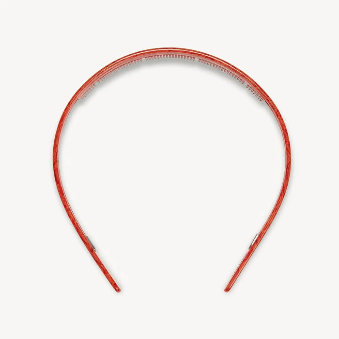 The MACHETE Ultralight Thin Headband in Poppy, crafted from Italian acetate in a vibrant marbled orange and hand-polished for a smooth finish, is shown against a plain white background.