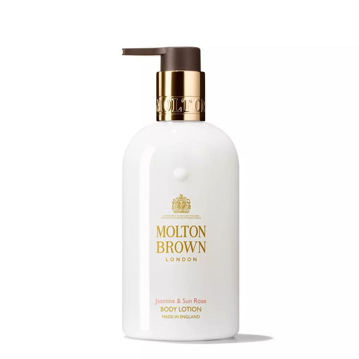 A white MOLTON BROWN JASMINE AND SUN ROSE BODY LOTION bottle with a gold pump stands upright on a white background, featuring a floral scent with hints of patchouli.