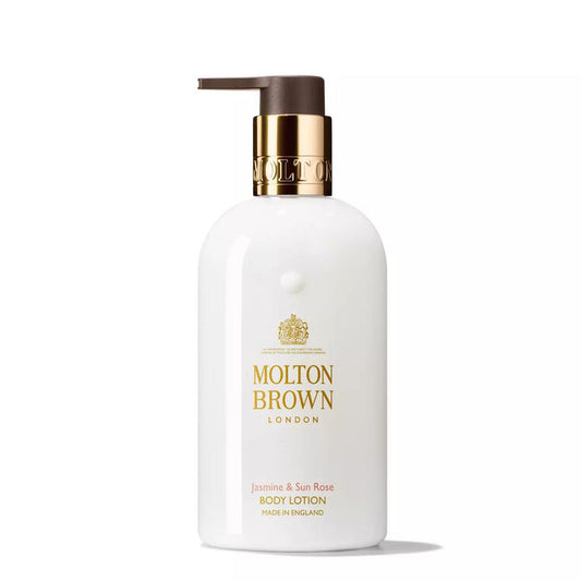 A white MOLTON BROWN JASMINE AND SUN ROSE BODY LOTION bottle with a gold pump stands upright on a white background, featuring a floral scent with hints of patchouli.