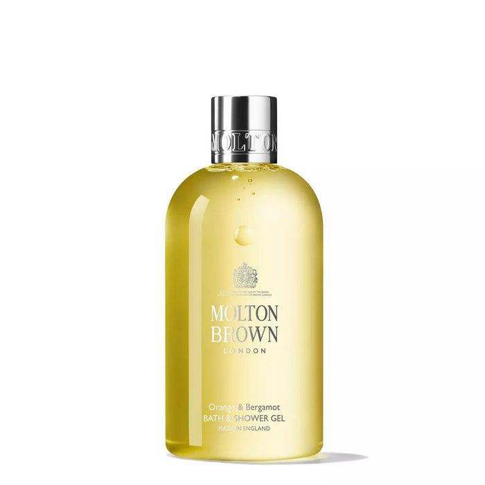 A clear yellow bottle of MOLTON BROWN - ORANGE AND BERGAMOT BATH & SHOWER GEL with a silver cap is shown on a white background. The label displays white and silver text for the MOLTON BROWN brand.