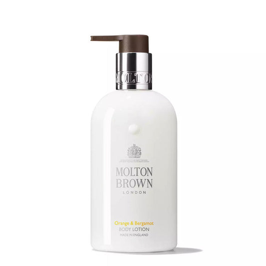 A white MOLTON BROWN - ORANGE AND BERGAMOT BODY LOTION bottle with a silver and brown pump, featuring grey and gold label text and infused with the iconic scent of Sevillian orange.
