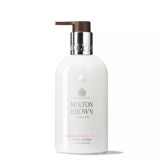 A white bottle of MOLTON BROWN Rhubarb and Rose Hand Lotion features a silver and brown pump and branded labeling.