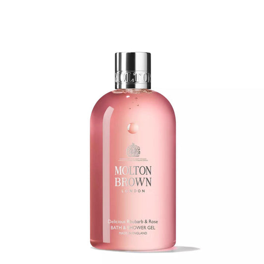 A clear pink bottle of MOLTON BROWN Rhubarb and Rose Hand Wash, featuring a silver cap, white label text, and the brand logo against a white background. This luxurious hand wash offers notes of rhubarb leaf and rose.